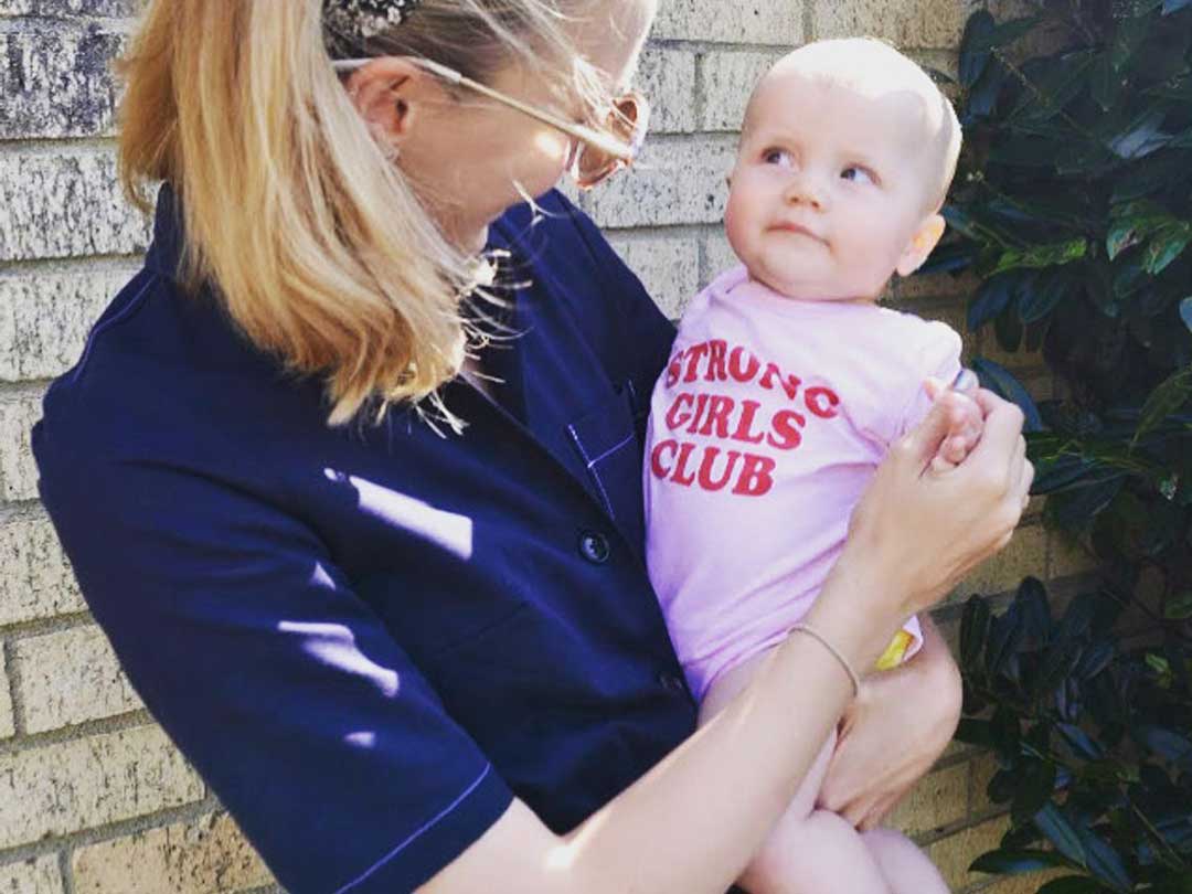 Mum wearing a New Plymouth Boiler Suite holding baby