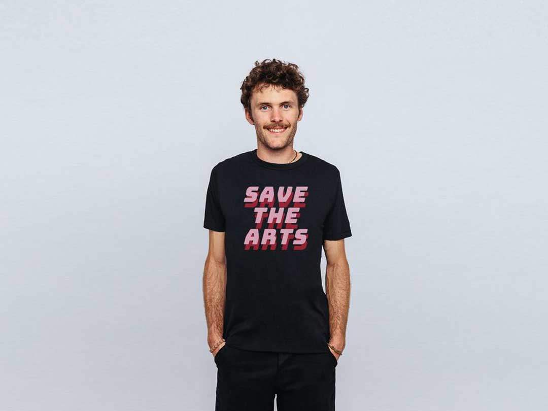 Young male wearing a save the arts t-shirt